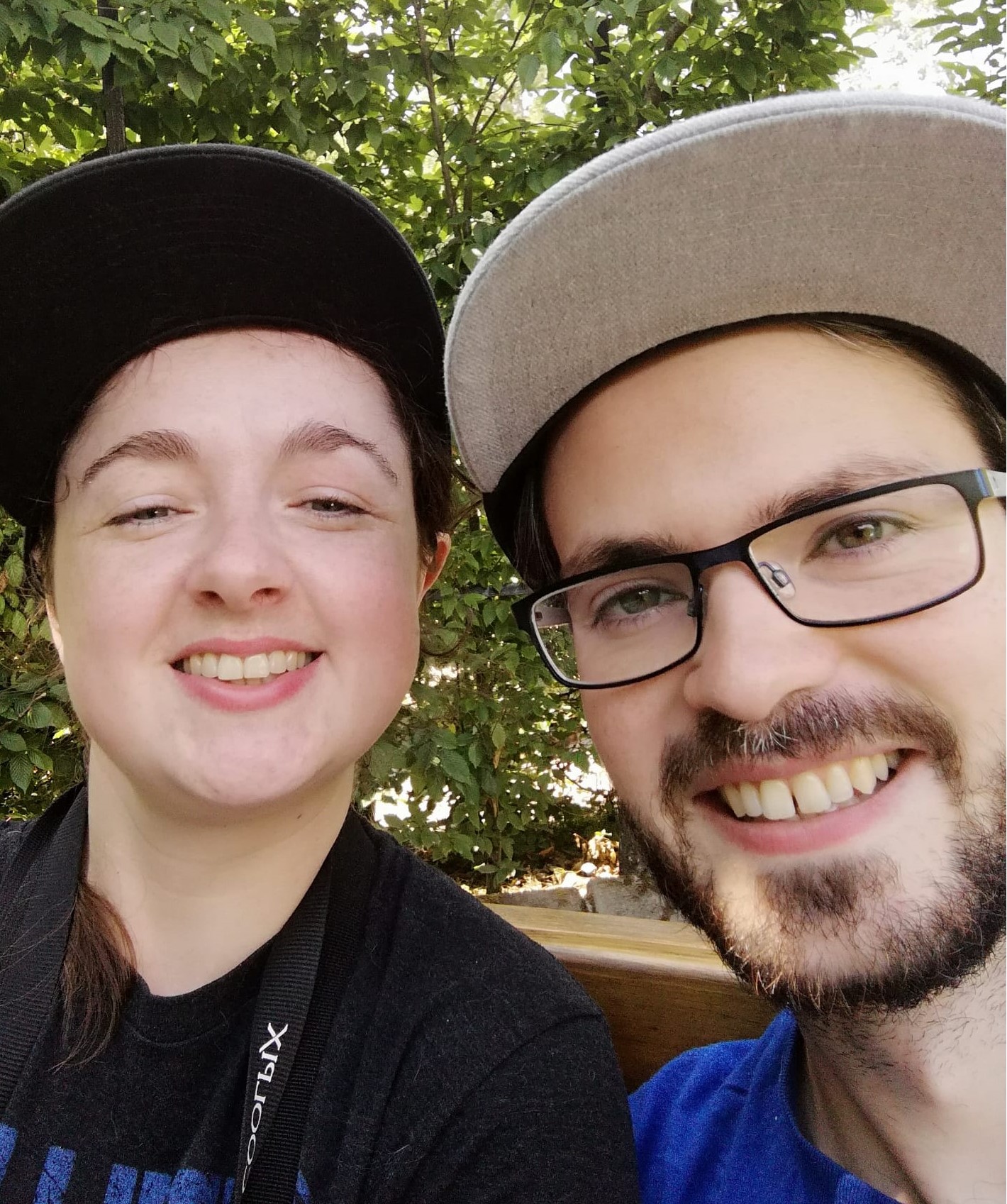 Conor and Clare smiling in caps on a sunny day.